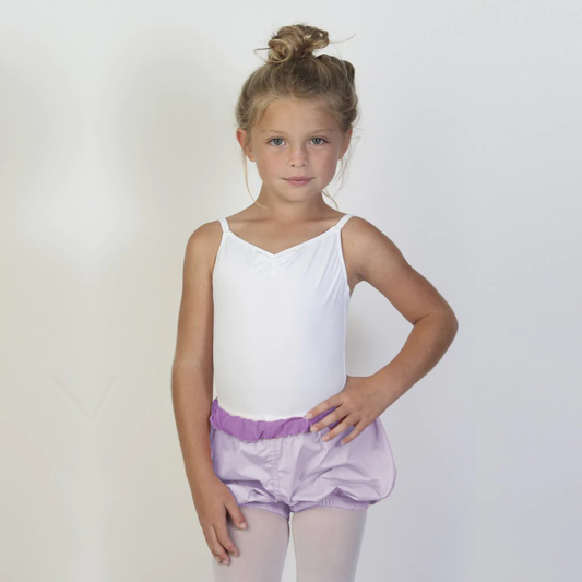 A young ballerina wears purple trash-bag style shorts with a darker purple waistband.