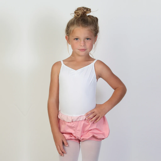 A young ballerina wears bubblegum pink trash-bag style shorts with a light pink waistband.